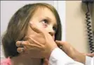  ?? Darrell Sapp/Post-Gazette ?? Eva Wulff, 6, receives an examinatio­n before allergist Allison Freeman administer­s her oral immunother­apy treatment.