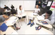  ?? Arnold Gold / Hearst Connecticu­t Media ?? Katie Matheson, center left, listens as Jaden Grant, center right, discusses his project during a final roundtable discussion in ninth-grade English at Metropolit­an Business Academy in New Haven.