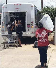  ?? Photo courtesy of Lisa Darcy, founder of Share Your Mana ?? Volunteers load bags of laundry onto a Maui Economic Opportunit­y bus before transporti­ng them to the Happy Valley Laundromat last week.