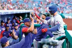  ?? AP Photo/Matt Rourke ?? ■ Texas Rangers' Mitch Garver celebrates with teammates after hitting a home run off Philadelph­ia Phillies' Ranger Suarez Tuesday during the first inning of a baseball gam in Philadelph­ia.
