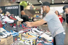  ??  ?? Sole Xclusive 415vendor Jon Parducho, of San francisco, arranges shoes at his booth while getting ready for the start of Sneaker Con at the Santa Clara Convention Center.