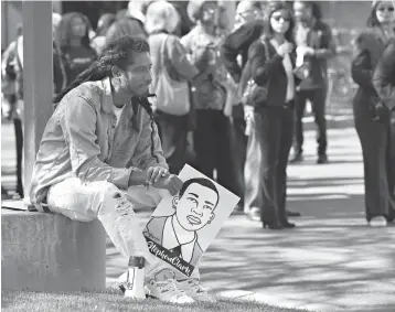  ??  ?? ■ ABOVE: Steven Ash holds a drawing of police shooting victim Stephon Clark on Thursday as he waits to enter the Bayside of South Sacramento Church, known as BOSS Church, for Clark’s funeral in Sacramento, Calif. Clark, who was unarmed, was shot and...