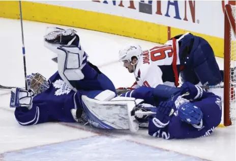  ?? RICK MADONIK/TORONTO STAR ?? Capitals OT hero Marcus Johansson bowls over Leafs goalie Frederik Andersen after tangling with defenceman Matt Hunwick in the crease in Game 6.