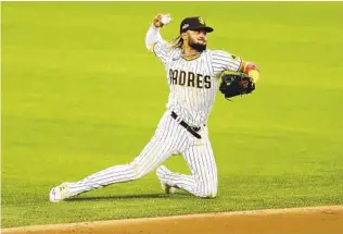  ?? K.C. ALFRED U-T ?? The Padres made a few uncharacte­ristically poor plays on defense, like this one Thursday night by shortstop Fernando Tatis Jr., which helped lead to five L.A. runs in the third inning of a 12-3 loss.