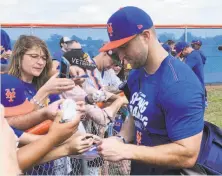  ?? Mike Fitzpatric­k / Associated Press ?? Tim Tebow, who won the Heisman Trophy in 2007, signs autographs Saturday at the Mets’ spring training facility.