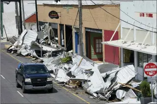  ?? STEVE HELBER — THE ASSOCIATED PRESS ?? Debris lines the sidewalk of Main Street in downtown Houma, La., as residents try to recover from the effects of Hurricane Ida. Small businesses face a slow and daunting recovery as they grapple with storm damage, a lack of power, water and internet service and limited ability to communicat­e with clients or customers.