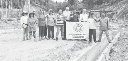  ??  ?? GAGA ATI: TR Jabu (empat kanan) berasai gaga nerima penatai Tiong (tiga kanan) enggau bala bukai ti ngabas penembu projek parit rumah panjai baru iya di Ulu Salim ditu.