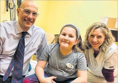  ?? SUBMITTED PHOTO ?? Skyla Bennett, centre, smiles wide after getting a good report from her annual checkup at the Tumour Clinic at the IWK Hospital in Halifax. On the left is her surgeon, Dr. Simon Walling, and his attending nurse is on the right.