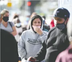  ?? ROBYN BECK / AFP via Gett y Imag es ?? People wait in line for a Thanksgivi­ng meal take-home
food kit at a mission in Los Angeles on Friday.