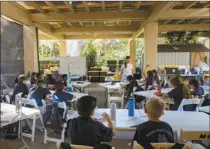  ?? ?? Sacred Hearts School second grade teacher Courtney Copriviza interacts with the fourth graders at their temporary school site at Sacred Hearts Mission Church on Oct. 3 in Lahaina. Sacred Hearts and other private schools across the state took in displaced public school students and offered a year of free tuition.