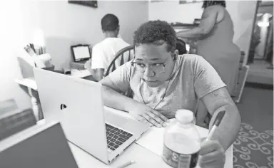  ?? MAX GERSH/THE COMMERCIAL APPEAL ?? Khila Harris, 15, takes notes while attending school virtually Monday from her home in Memphis.