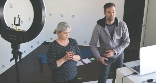  ?? BRANDON HARDER ?? Barb Mccaslin, left, and Colin Hall speak to participan­ts in an interactiv­e Web-based yoga class being run at Bodhi Tree Yoga now that regular classes have been closed over social distancing concerns. The Regina yoga studio is also offering two free interactiv­e meditation classes per week.