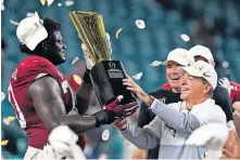  ?? [AP PHOTO/CHRIS O'MEARA] ?? Alabama hoisting the national championsh­ip trophy, as offensive lineman Alex Leatherwoo­d and head coach Nick Saban did last week, has become an almost annual event.