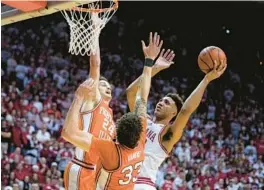  ?? MICHAEL CONROY/AP ?? Indiana forward Trayce Jackson-Davis, right, shoots over Illinois forwards Coleman Hawkins (33) and Matthew Mayer in the second half Saturday.