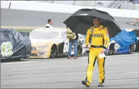  ?? (AP/Terry Renna) ?? Erik Jones walks down pit road Sunday after rain caused a delay in the NASCAR Daytona 500 auto race at Daytona Internatio­nal Speedway in Daytona Beach, Fla.