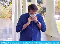  ??  ?? BRASILIA: A screen grab shows Brazilian President Jair Bolsonaro putting a facemask on as he prepares to speak with journalist­s at Planalto Palace on Tuesday. — AFP