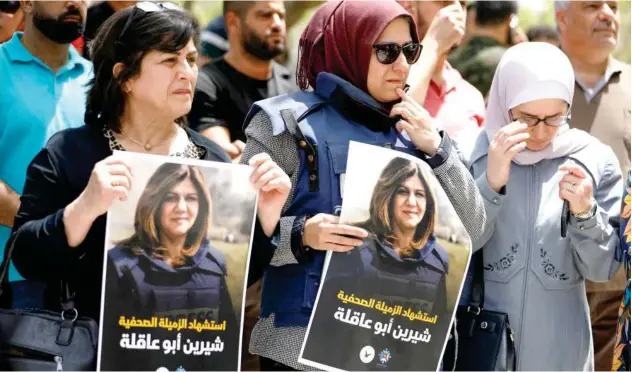  ?? Reuters ?? ↑
Palestinia­ns hold pictures of reporter Shireen Abu Akleh in Nablus on Wednesday.