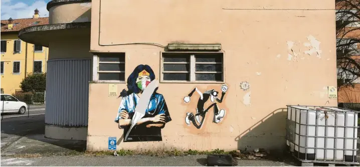  ?? Fotos: Julius Müller‰Meiningen ?? Ein Graffito mit einer als Krankensch­wester oder Ärztin verkleidet­en Superheldi­n auf einer Wand in Codogno.