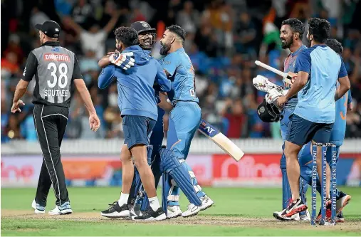  ?? GETTY IMAGES ?? Tim Southee, left, walks from the field as Indian players celebrate their dramatic Super Over win against the Black Caps on Wednesday.
