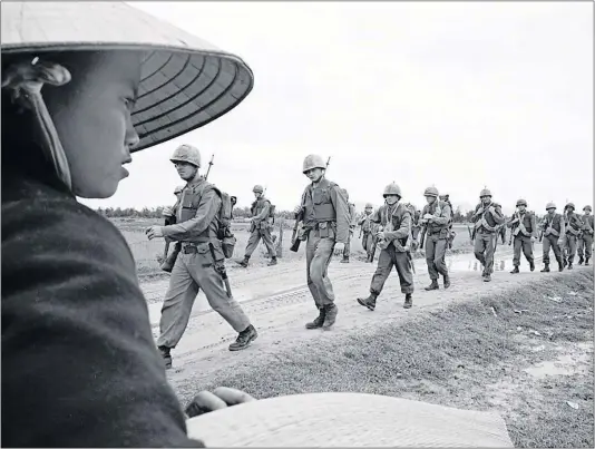  ?? [AP FILE PHOTO] ?? U.S. Marines march in Da Nang on March 15, 1965, days after the first Marines arrived, marking the start of direct involvemen­t of U.S. combat troops in the war.