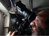  ?? ROBERTO VERDECCHIA ?? Director of photograph­y Derek Rogers shoots closeups of a cellar spider in the Vettese family’s basement window.