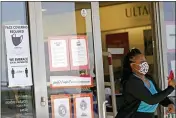  ?? LM OTERO — THE ASSOCIATED PRESS ?? A customer exits a store with a mask required sign displayed, on Tuesday in Dallas.