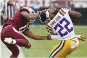  ?? AP Photo/Rogelio V. Solis ?? ■ Mississipp­i State safety Jaquarius Landrews (11) pulls the helmet off LSU running back Clyde Edwards-Helaire (22) during the first half of their NCAA college football game Saturday in Starkville, Miss. Landrews was flagged for a personal foul.