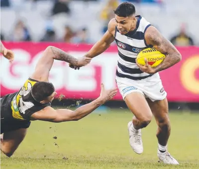  ??  ?? AWAY: Geelong's Tim Kelly breaks a tackle attempt by Richmond's Jack Graham. Picture: MICHAEL KLEIN