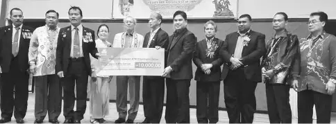  ??  ?? Riot (fifth left) witnesses the presentati­on of a mock cheque from Socso deputy CEO John Riba Marin (fifth right) to a representa­tive from a recipient.