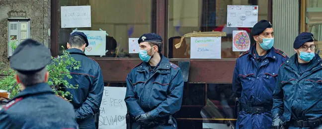  ?? (foto Ottico) ?? Al portone
Il presidio dei militari dell’Arma dei carabinier­i davanti al palazzo dove vive Silvia Romano il giorno del suo ritorno a casa. Sulla vetrata del portone d’ingresso della casa, i numerosi messaggi di bentornato dei vicini, degli amici e degli abitanti del quartiere