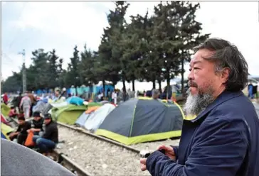  ?? DANIEL MIHAILESCU/AFP ?? Chinese artist Ai Weiwei visits a makeshift camp on March 11, 2016, at the Greek-Macedonian border, near the Greek village of Idomeni, where thousands of refugees and migrants are stranded by the Balkan border blockade.
