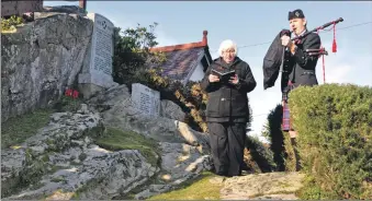  ??  ?? Parish assistant Jean Hunter conducts the remembranc­e service in Corrie in 2019 with piper Malcolm Wheeler.