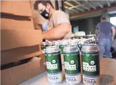  ?? MICHAEL SEARS, MILWAUKEE JOURNAL SENTINEL ?? Rome Gandelsman of Gathering Place puts Arrivederc­i Roma Beer into boxes on Aug. 17. Gathering Place beer was being canned at Company Brewing.