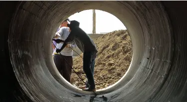  ?? BING GONZALES ?? A man works on the drainage before it will be installed at the Bago-Talomo coastal bypass road. The segment will be partially opened to traffic by the end of February.