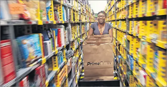  ?? [DISPATCH FILE PHOTO] ?? Tanazja Johnson fills orders in the Amazon Prime Now hub on the West Side. The warehouse is one of two distributi­on centers Amazon has in central Ohio. There also are three data centers.