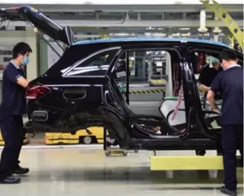  ??  ?? The staff of Beijing Benz Automotive Co. work on the production line on February 21