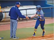  ?? STAFF PHOTO BY OLIVIA ROSS ?? UTC’S Kaili Phillips hive fives her coach as she runs in off a home run against ETSU at home on April 2, 2022.