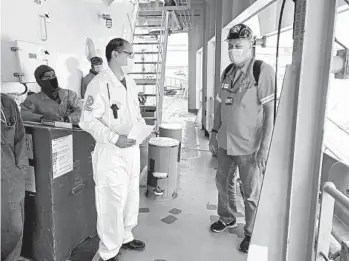  ?? RONALD D. WHITE LOS ANGELES TIMES ?? Fe Mar Logronio Quintana (in white), captain of the MV Ocean Satoko, talks to Stefan Mueller-Dombois, a ship inspector with the Internatio­nal Transport Workers’ Federation, while his ship was docked.