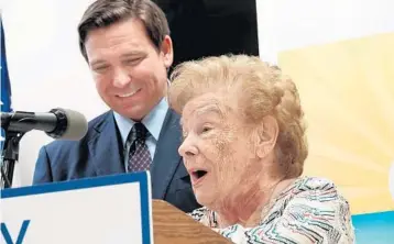  ?? JOE CAVARETTA/SOUTH FLORIDA SUN SENTINEL ?? Florida Gov. Ron DeSantis listens to Pauline Becker, 92, at a news conference in West Palm Beach on Thursday. Becker is a COVID-19 survivor who was treated with monoclonal antibodies.