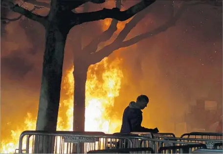  ?? Ben Margot Associated Press ?? IN THIS PHOTO from Feb. 1, a fire set by demonstrat­ors protesting a scheduled speaking appearance by right-wing provocateu­r Milo Yiannopoul­os burns in Sproul Plaza on the UC Berkeley campus. Some in the university town have blamed violence on outsiders.