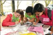  ?? NWA Democrat-Gazette/FLIP PUTTHOFF ?? Carley Harris (from left), Mallory Price and Melina Rice write their outdoor stories on May 4 during Lingle Middle School Outdoor School held at Prairie Creek park on Beaver Lake.