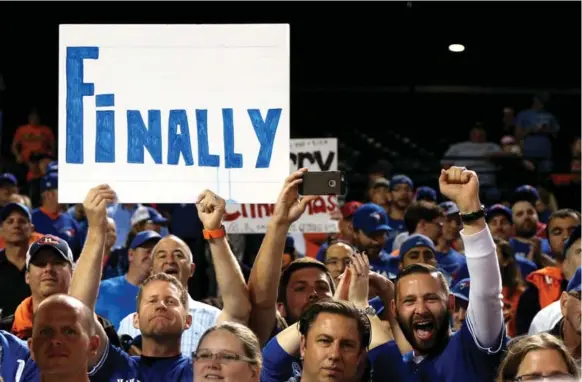  ?? PATRICK SMITH/PATRICK SMITH/GETTY IMAGES ?? These diehard fans hold aloft a sign that says it all after the Blue Jays clinched their first AL East division title in 22 years with a win over the Orioles in Game 1 of Wednesday’s double-header.