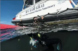  ?? DAVID J. PHILLIP — THE ASSOCIATED PRESS ?? Kimberly Roberson, research coordinato­r for Gray’s Reef National Marine Sanctuary, foreground, and Justin Miyano surface after scuba diving in the sanctuary Monday off the coast of Savannah, Ga.