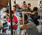  ??  ?? Wounded Palestinia­ns wait for medical care at a Doctors Without Borders clinic because of an overflow of patients at hospitals in Gaza City. The local health system has been pushed to the brink by recent violence.