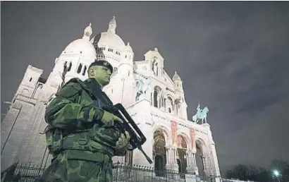  ?? JOEL SAGET / AFP ?? Militars al carrer. Un soldat, desplegat en virtut del pla antiterror­ista francès, patrulla amb armes de guerra davant la basílica del Sacré-Coeur de París per reforçar la vigilància policial