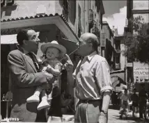  ?? (Photo Robert Joffres/Collection Institut audiovisue­l de Monaco) ?? Une scène du film entre Jules Mushin, Max Elloy et le fameux bébé, tournée place Saint-Nicolas à Monaco-ville, où on retrouve l’atmosphère du quartier de l’époque.