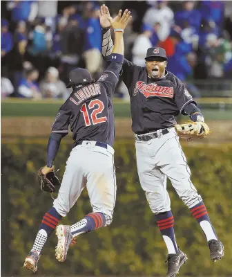  ?? AP PHTO ?? JUMPING FOR JOY: Cleveland Indians teammates Rajai Davis, right, and Francisco Lindor celebrate after their Game 4 win in the World Series against the Cubs last night in Chicago. The Indians won 7-2 to take a 3-1 lead in the series.