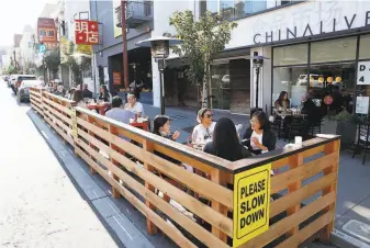  ?? Scott Strazzante / The Chronicle ?? Customers eat at a parklet on an elevated platform that China Live owner George Chen built to accommodat­e diners at his restaurant in San Francisco Chinatown during the pandemic.