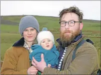  ?? 25_c19HRHIsla­y63 ?? The American monument is just visible in the mist above proud mum and dad Imogen Mathers and Oliver Brooks with Hero Mathers-Brooks, four months.