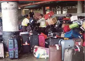  ?? PIC COURTESY OF READER ?? Workers handling passengers’ baggage at Kuala Lumpur Internatio­nal Airport in Sepang on Friday.